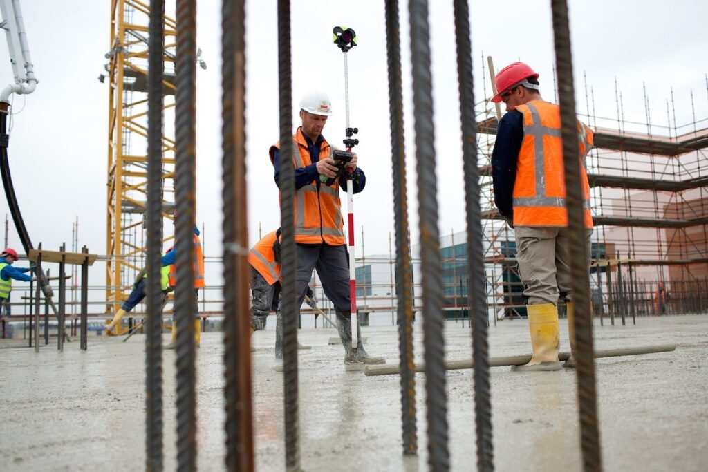 ndmeter voert bouwmaatvoering uit op een bouwplaats met GPS-meetapparatuur tussen wapening voor een nieuwbouwproject.
